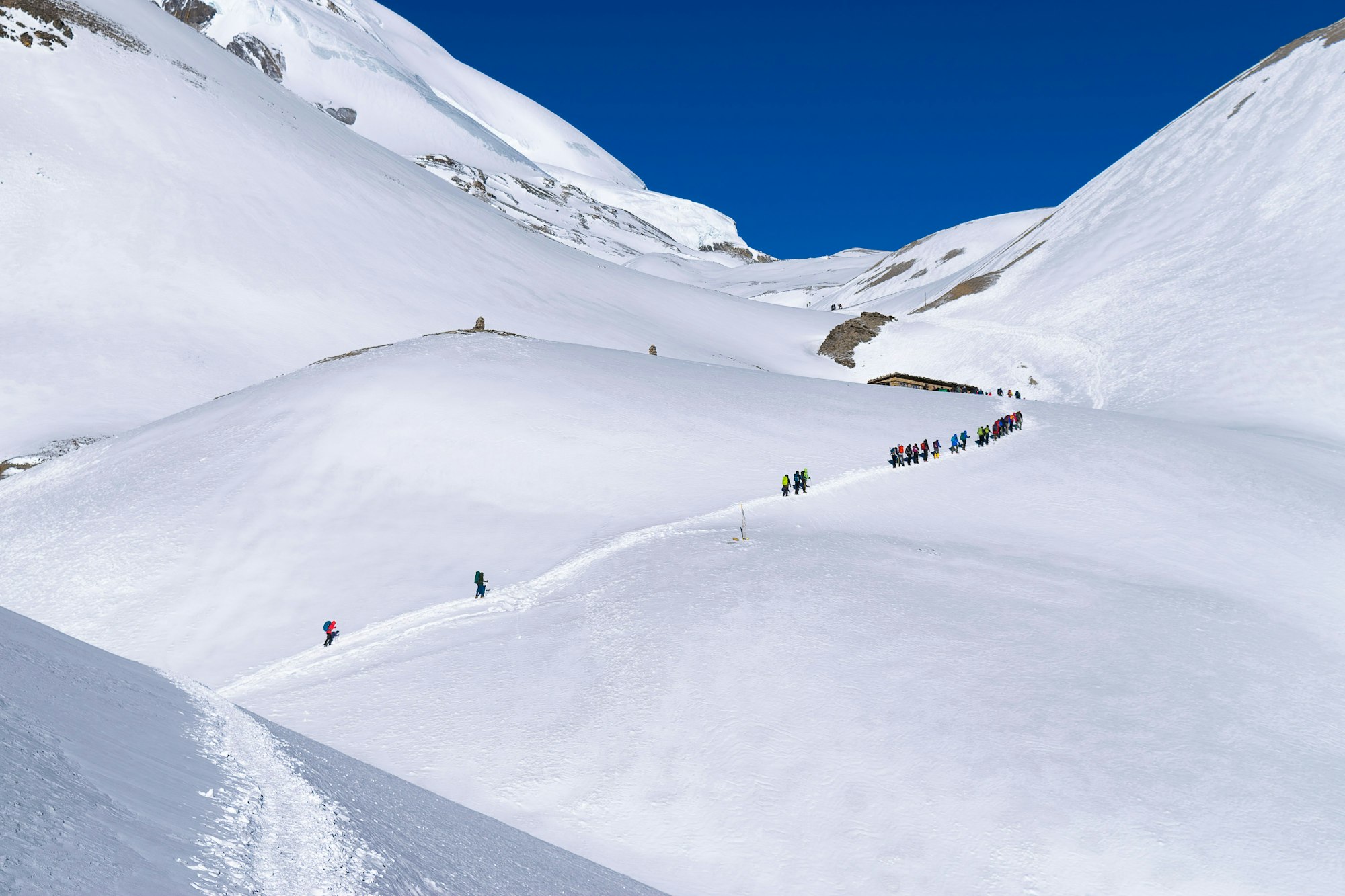 Group of hikers walking ascending to Thorong La mountain pass, Annapurna circuit trek, Nepal