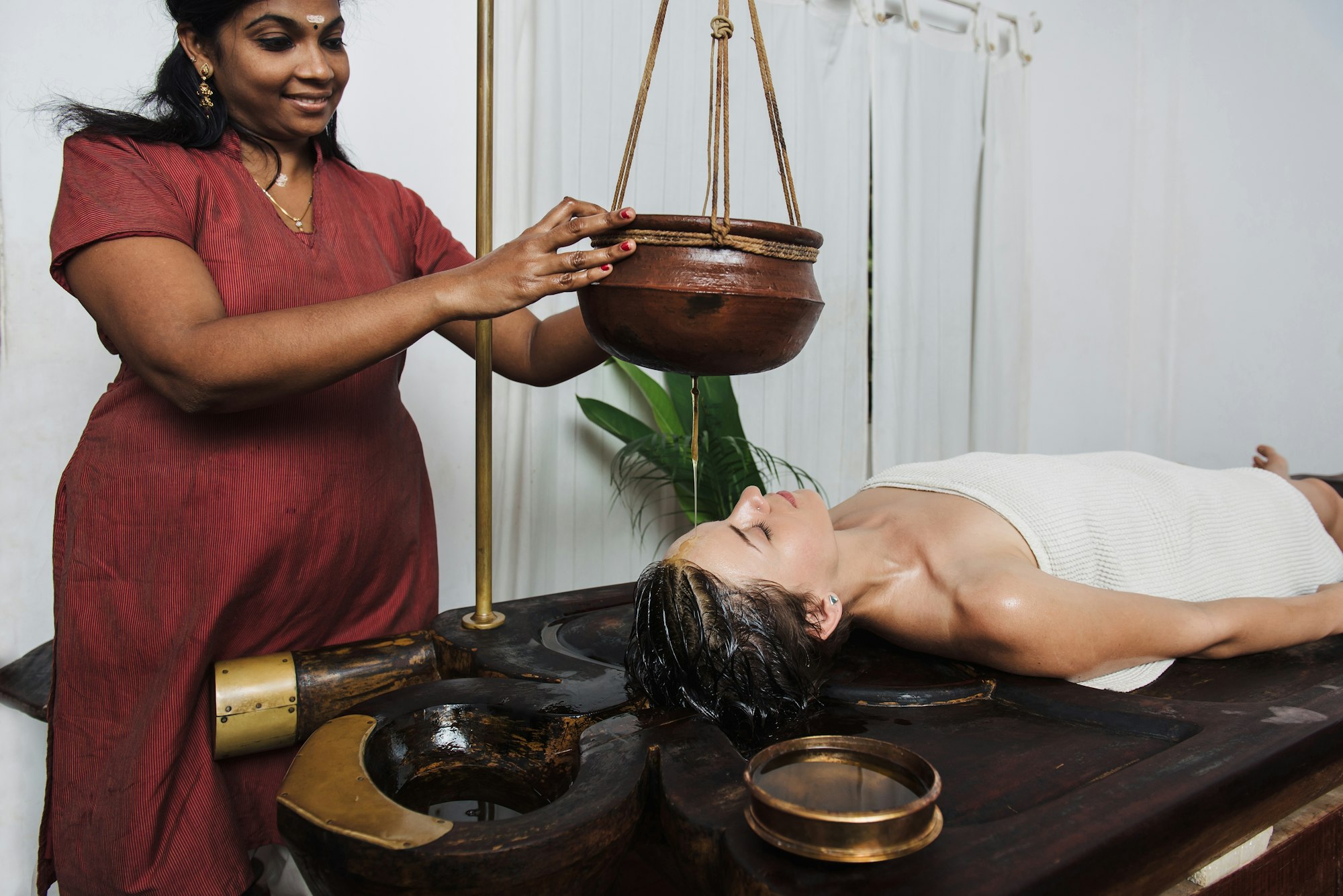 Caucasian woman having Ayurveda shirodhara treatment in India, Kerala state