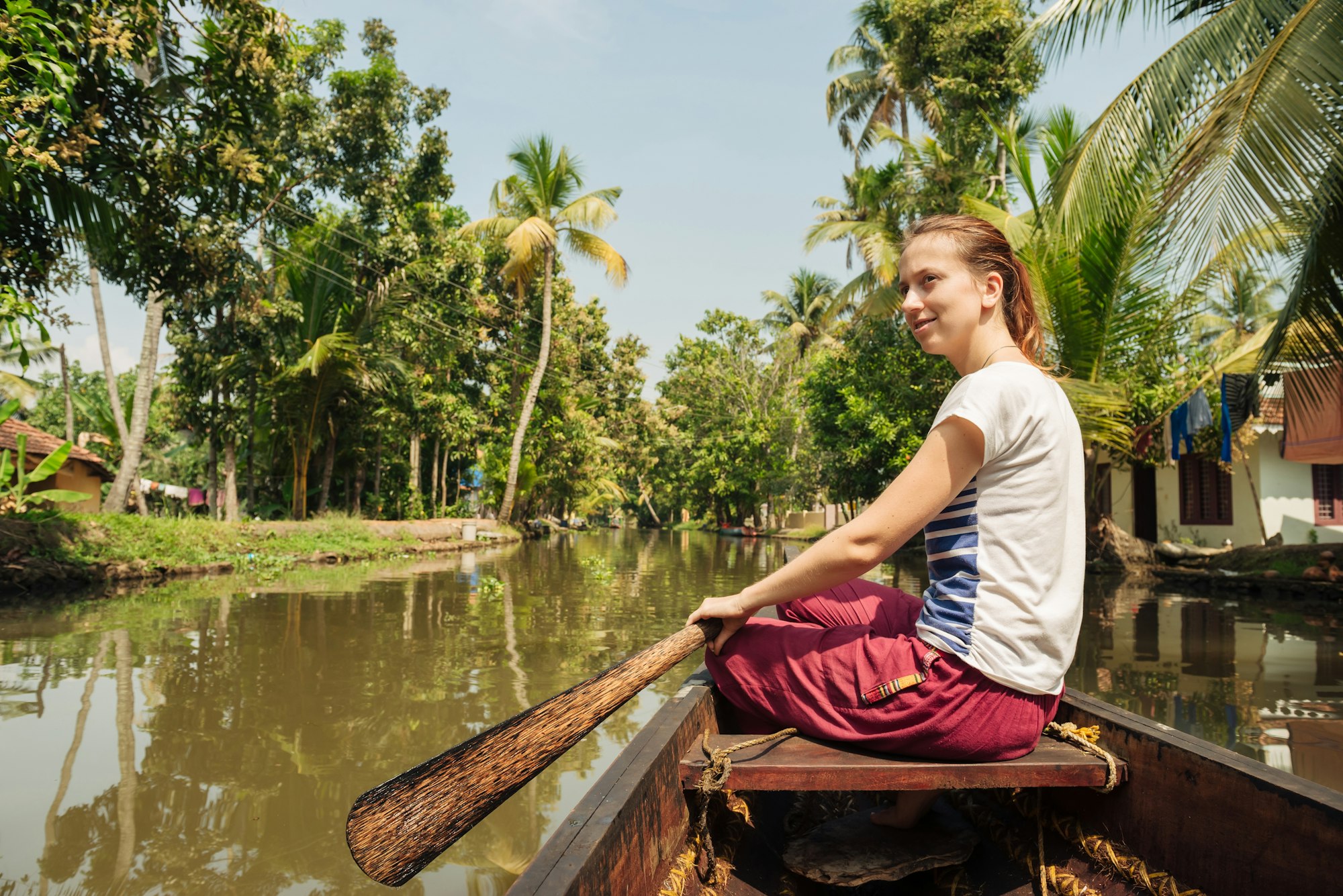 Tourist woman relaxing on Alleppey backwaters and enjoying beautiful view landscape. Kerala, India