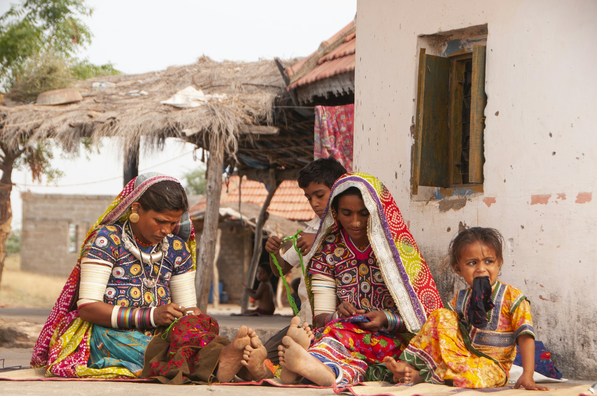 Tribal women in front of their hut, Kutch, Gujarat, India.