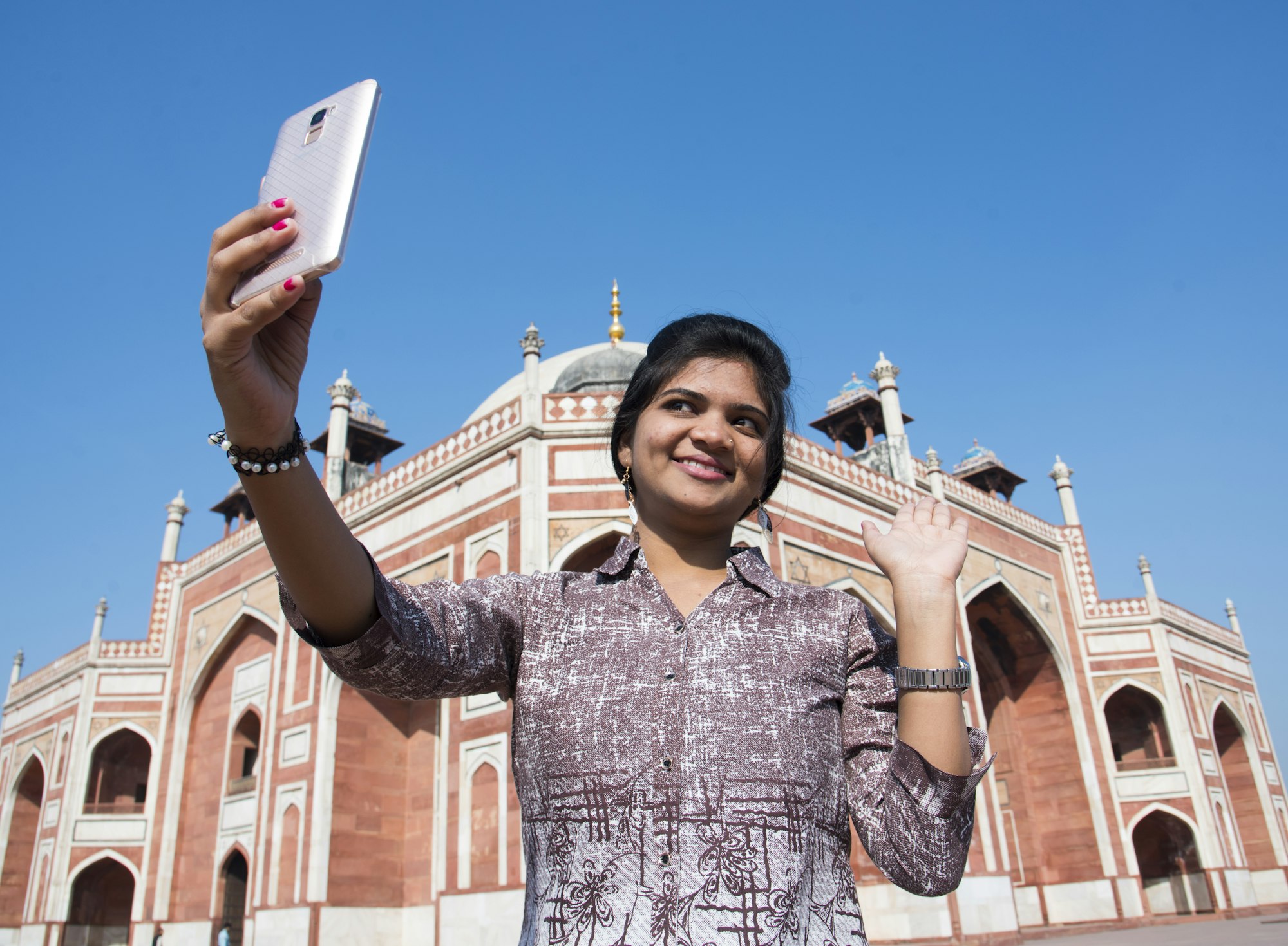 Young girl taking Photos in front of Humayun's Tomb, Delhi, India.