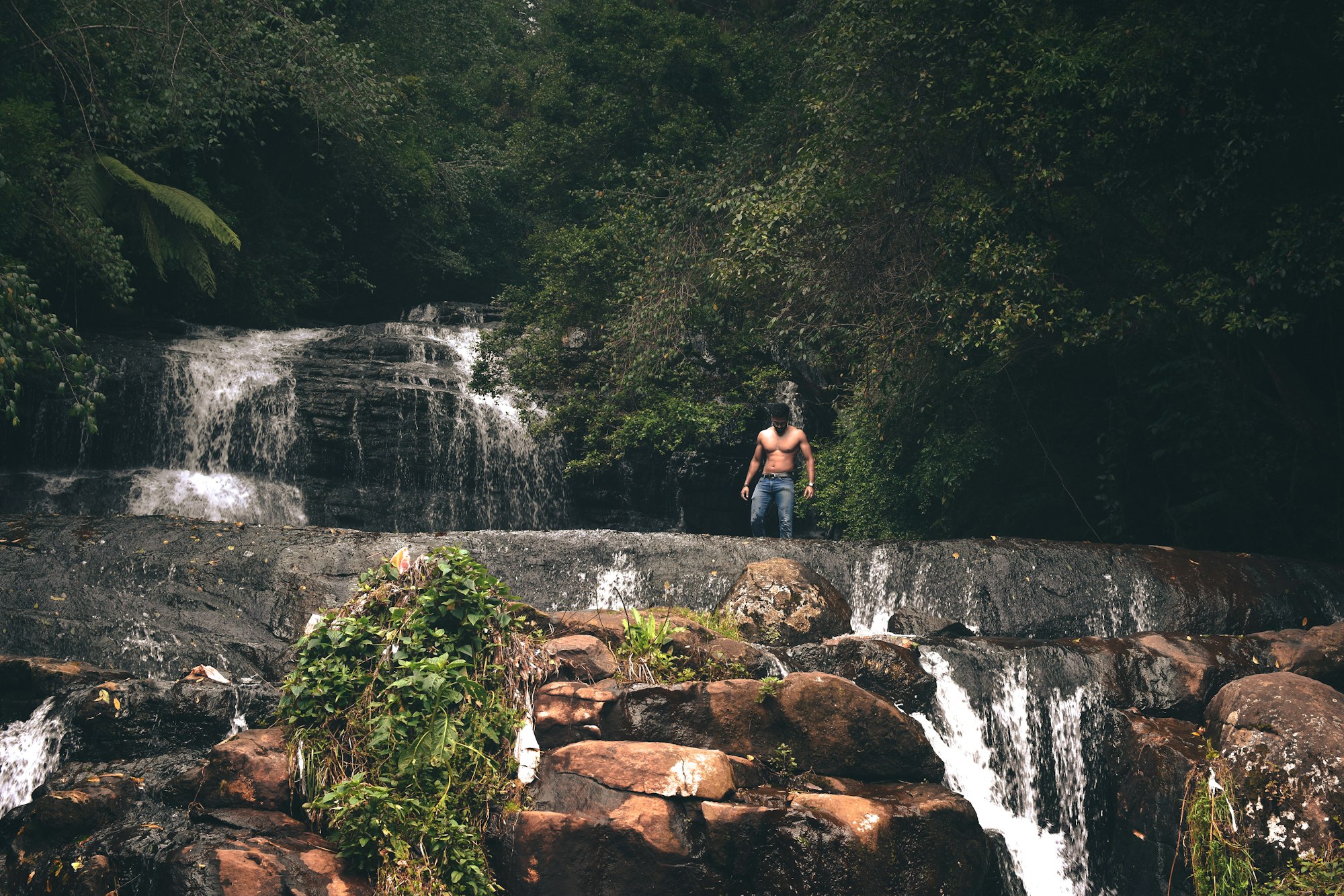 Topless man standing near waterfall in kodaikanal, india_Kodaikanal tour packages